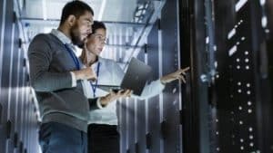 hommes devant des seveurs informatiques