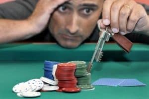 homme se prenant la tete devant pile de jetons